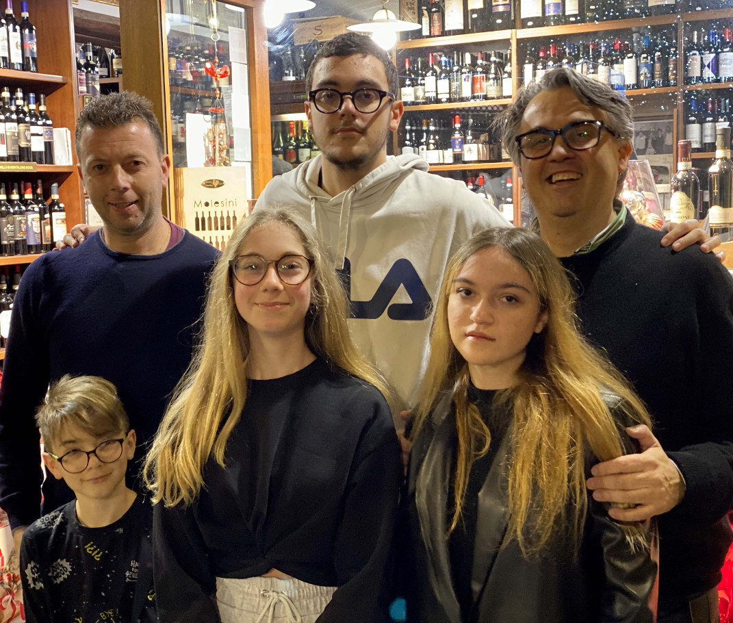 Foto dei fratelli Molesini con i figli scattata a Cortona, all'interno dell'Enoteca